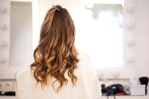 Krullend vrouw zitten in de kapsalon — Stockfoto