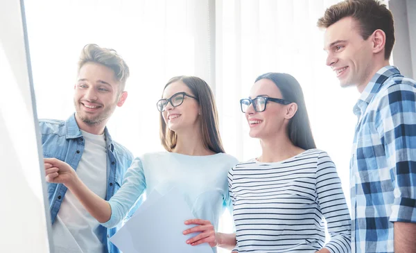 Zufriedene Kollegen, die an dem Projekt arbeiten — Stockfoto