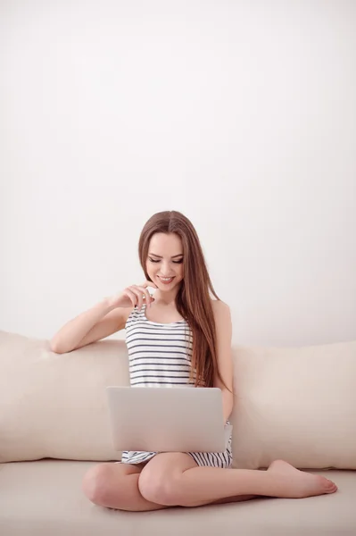 Fröhliches Mädchen sitzt auf dem Sofa — Stockfoto