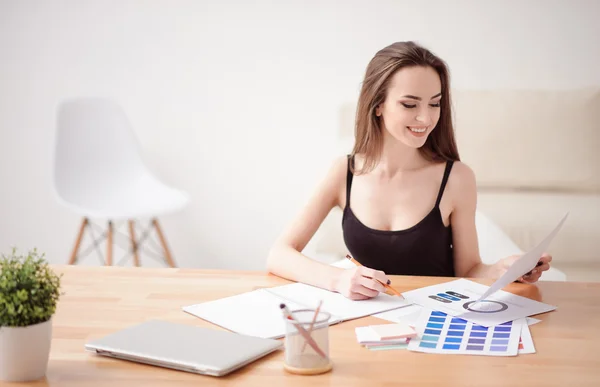 Vrolijk meisje dat aan tafel werkt — Stockfoto