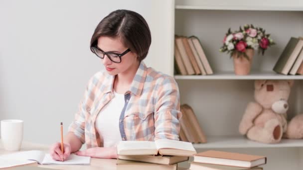 Menina inteligente está estudando duro em casa — Vídeo de Stock