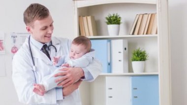 Profesyonel doktor holding toddler onun elinde