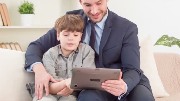 Pozytywny ojciec i syn siedzi na kanapie — Wideo stockowe