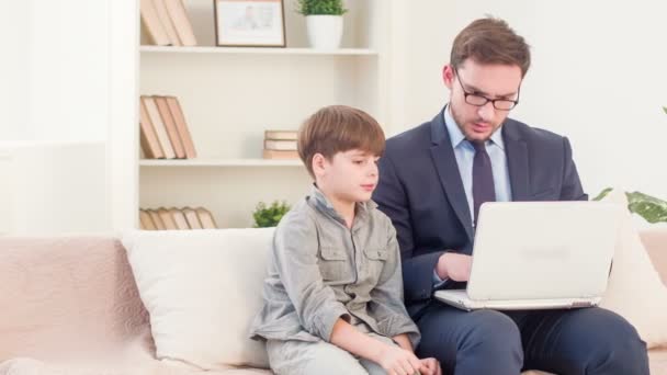 Vater und Sohn sitzen auf der Couch — Stockvideo