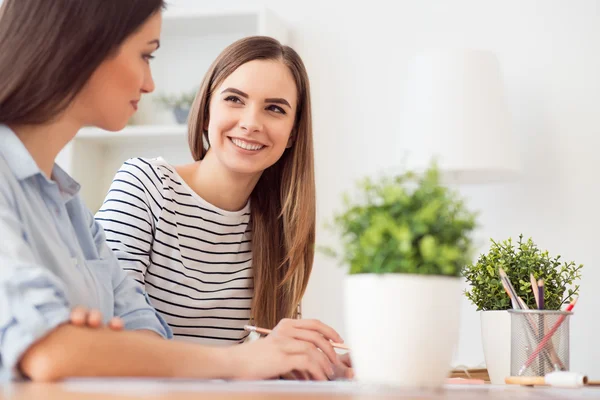 Menina alegre sentada à mesa — Fotografia de Stock