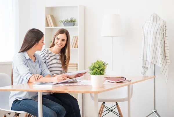 Positive girls sitting at the table — Stok fotoğraf