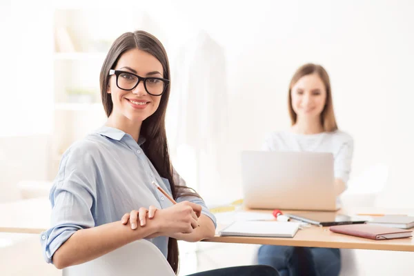 Trevlig tjej sitter vid bordet — Stockfoto