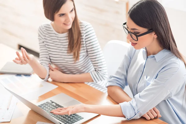 Pleasant girls sitting at the table — Stock Photo, Image