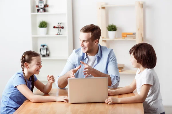 Positive father sitting at the table with kids — Stock Photo, Image