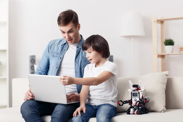 Delighted father and son sitting on the couch — Stock Photo, Image