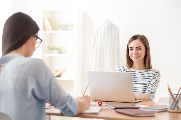 Schöne Mädchen sitzen am Tisch — Stockfoto