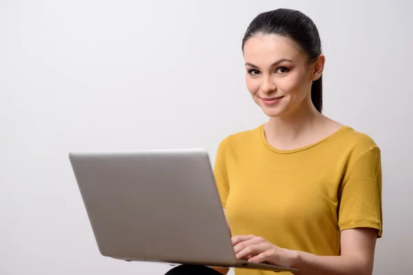 Menina encantada agradável usando laptop — Fotografia de Stock