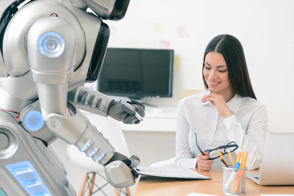 Buena chica trabajando con robot en la oficina —  Fotos de Stock