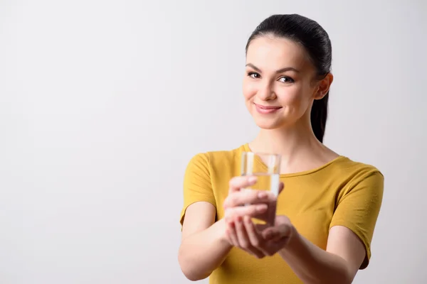 Cheerful girl holding glass of water — Stockfoto