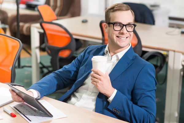 Delizioso uomo sorridente seduto a tavola — Foto Stock