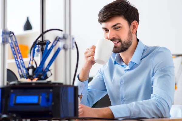 Agradable hombre sonriente utilizando la impresora 3d — Foto de Stock