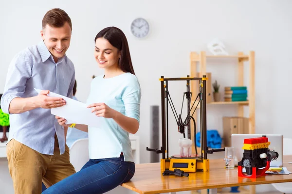 Glada studenter håller papper — Stockfoto