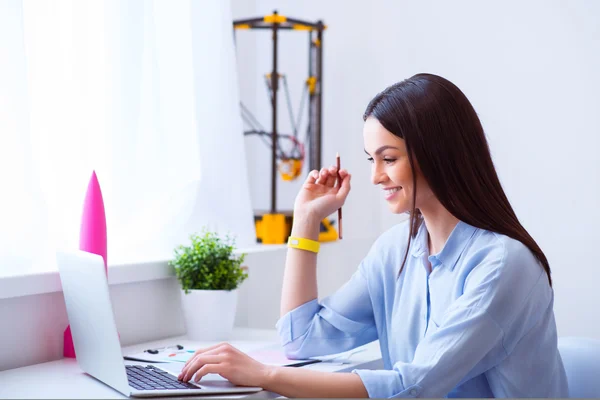 Schöne lächelnde Frau am Tisch sitzend — Stockfoto