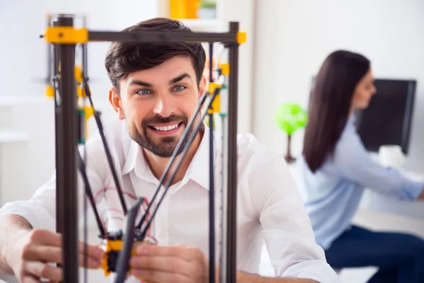 Zadowolony uśmiechnięty człowiek za pomocą drukarki 3D — Zdjęcie stockowe