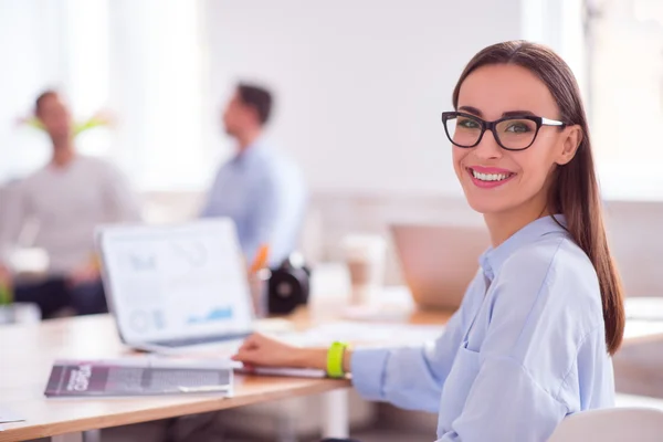 Mujer agradable sentada a la mesa —  Fotos de Stock