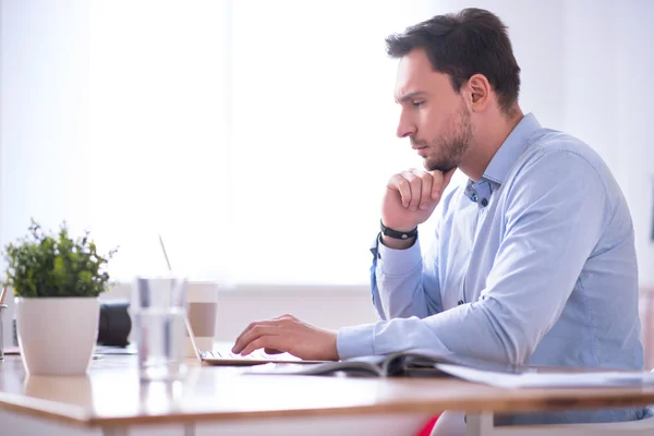 Koncentrerad man som arbetar på den bärbara datorn — Stockfoto