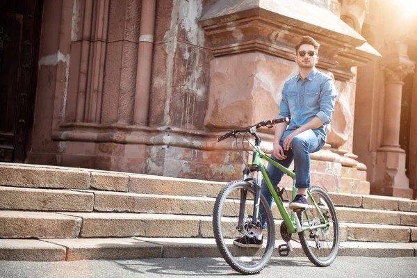 Bonitão sentado na bicicleta — Fotografia de Stock