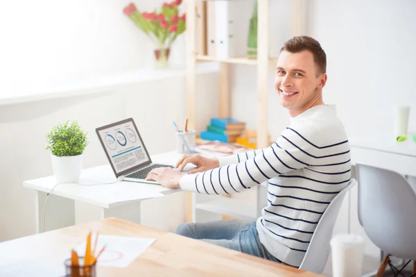 Begeisterter Kerl, der am Laptop arbeitet — Stockfoto