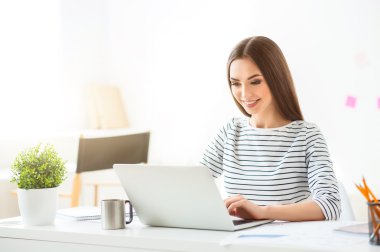 Dizüstü bilgisayarda çalışan pozitif kadın