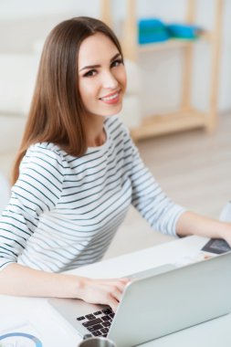 Dizüstü bilgisayarda çalışan pozitif kadın