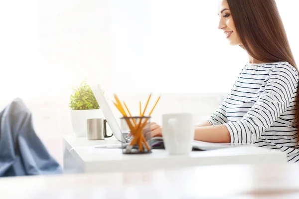 Positieve lachende vrouw die op laptop werkt — Stockfoto