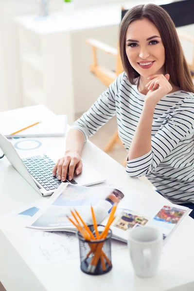 Dizüstü bilgisayarda çalışan içerik gülümseyen kadın