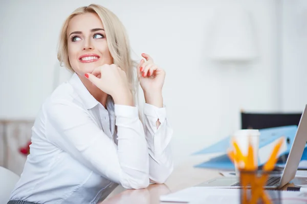 Fröhliche Frau sitzt im Büro — Stockfoto