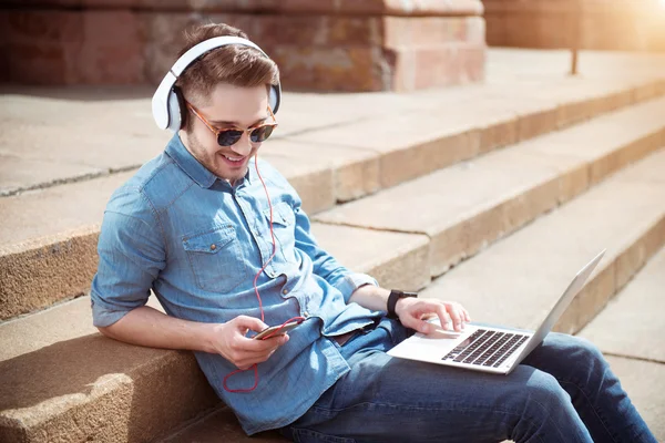 Zachwycony uśmiechający się facet, słuchanie muzyki — Zdjęcie stockowe