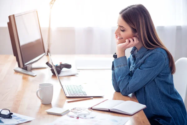 Angenehm lächelnd am Tisch sitzen — Stockfoto