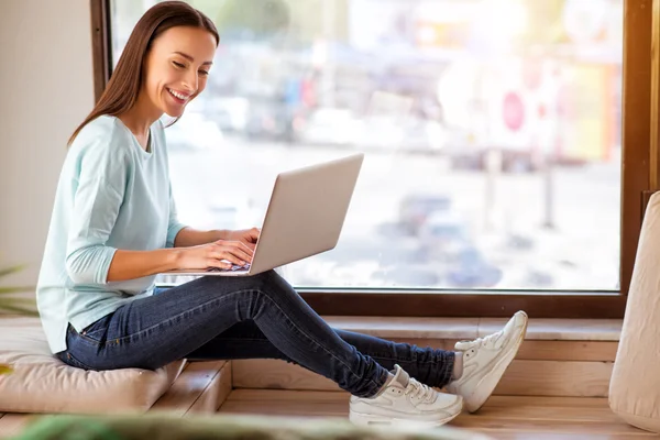 Mujer sonriente alegre usando el ordenador portátil — Foto de Stock