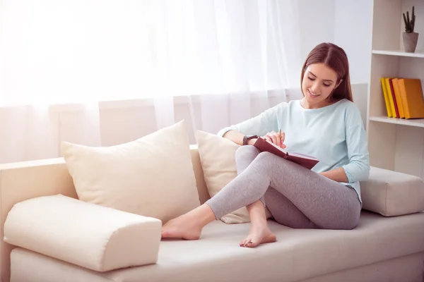 Mujer positiva descansando en el sofá — Foto de Stock