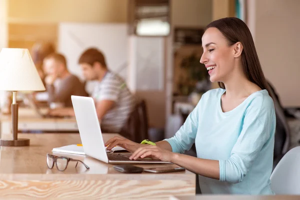 Nette Frau sitzt am Tisch — Stockfoto