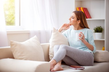 Pleasant beautiful woman resting on the couch