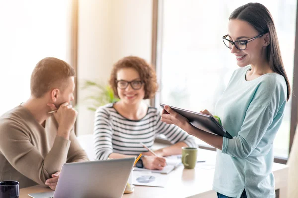 Angenehme Frau, die im Büro arbeitet — Stockfoto