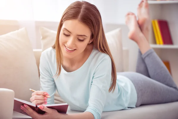 Mujer sonriente positiva descansando en el sofá — Foto de Stock