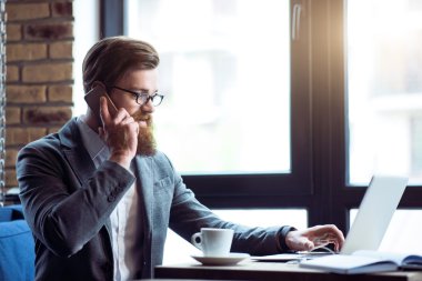 Cep telefonuyla konuşan olumlu sakallı adam