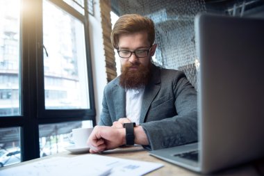 Masada oturan konsantre sakallı adam