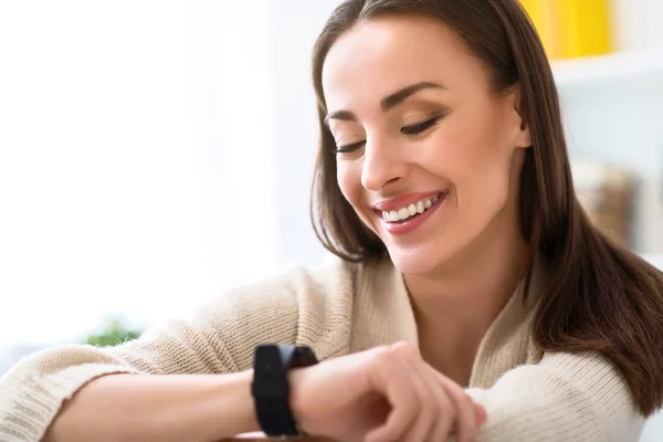 Mujer sonriente agradable sentada en la silla — Foto de Stock