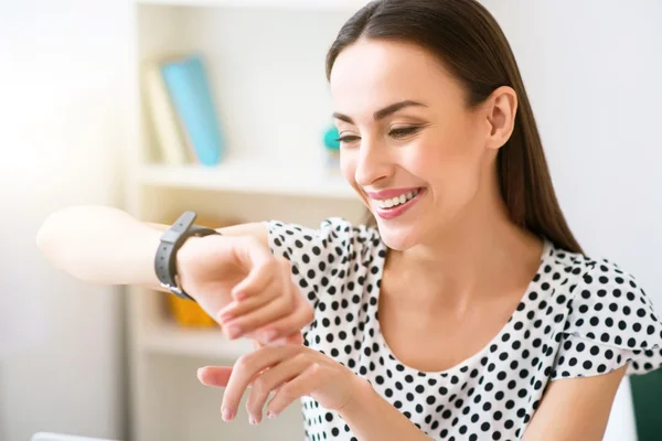 Mujer agradable usando su reloj de pulsera —  Fotos de Stock