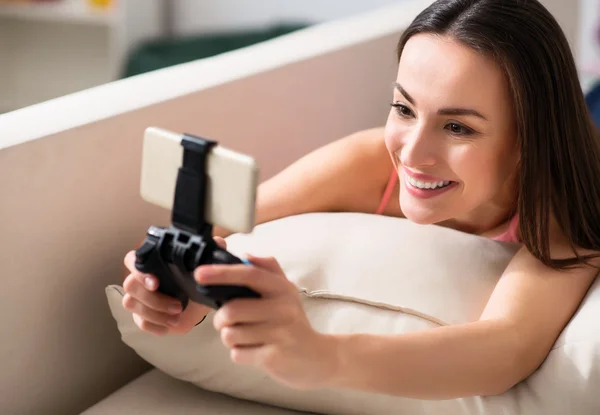 Mulher bonita agradável usando console de jogo — Fotografia de Stock