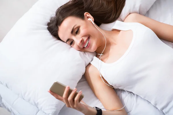 Overjoyed smiling  woman resting in bed — Stock Photo, Image