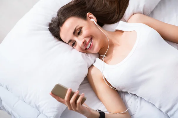 Mujer sonriente muy alegre descansando en la cama —  Fotos de Stock