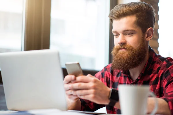 Positieve bebaarde man zit aan de tafel — Stockfoto