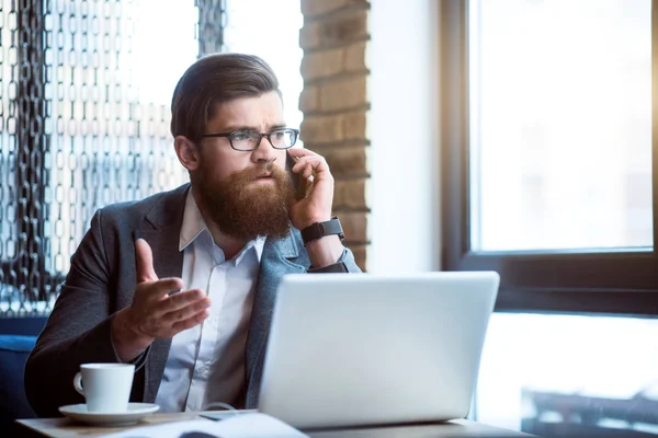 Ernstige bebaarde man praten op mobiele telefoon — Stockfoto