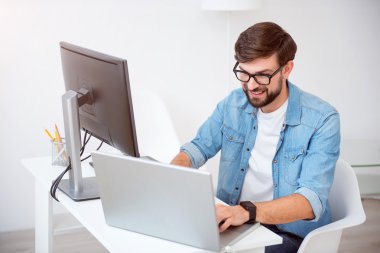 Mutlu genç adam onun laptop üzerinde çalışma
